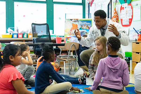 School 57 Elementary Ed 2019 173 Young science teacher in lab coat engaged with young students