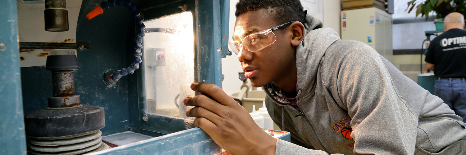 Male student working with equipment in the optics lab