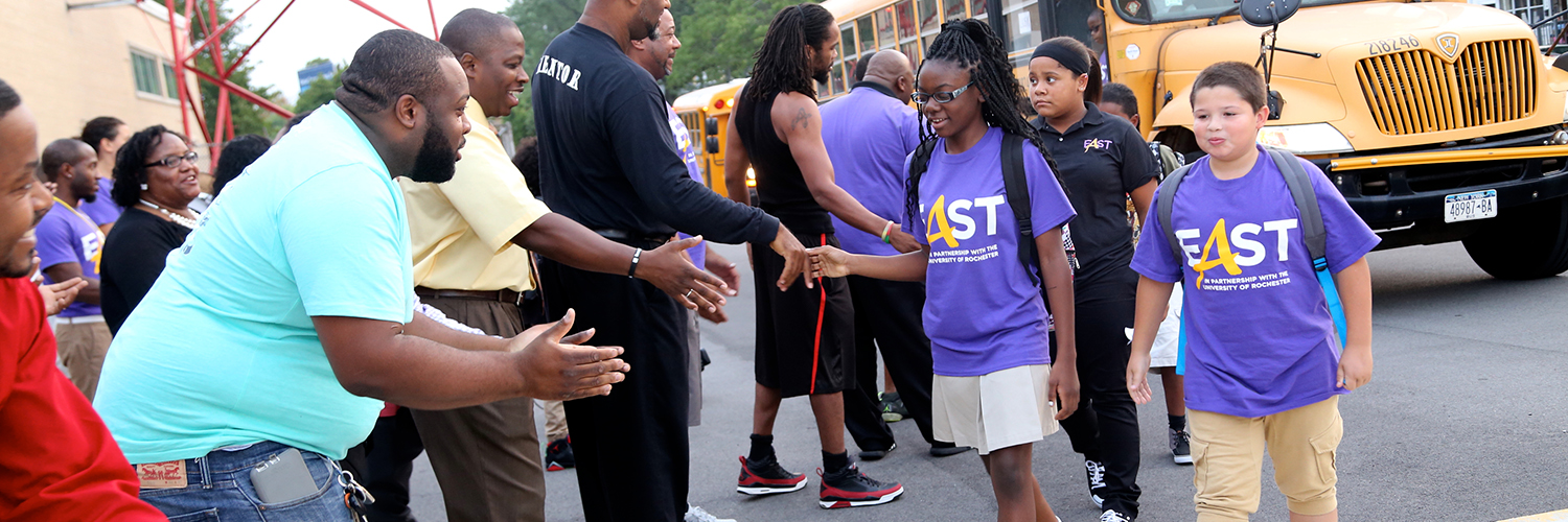 EX0227 East lower school students arriving at school on a yellow school bus and being greeting by community members