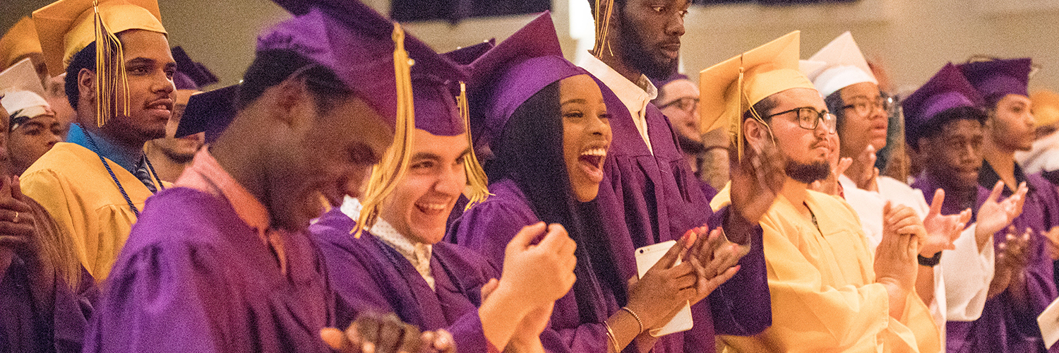Smiling graduates cheering at graduation