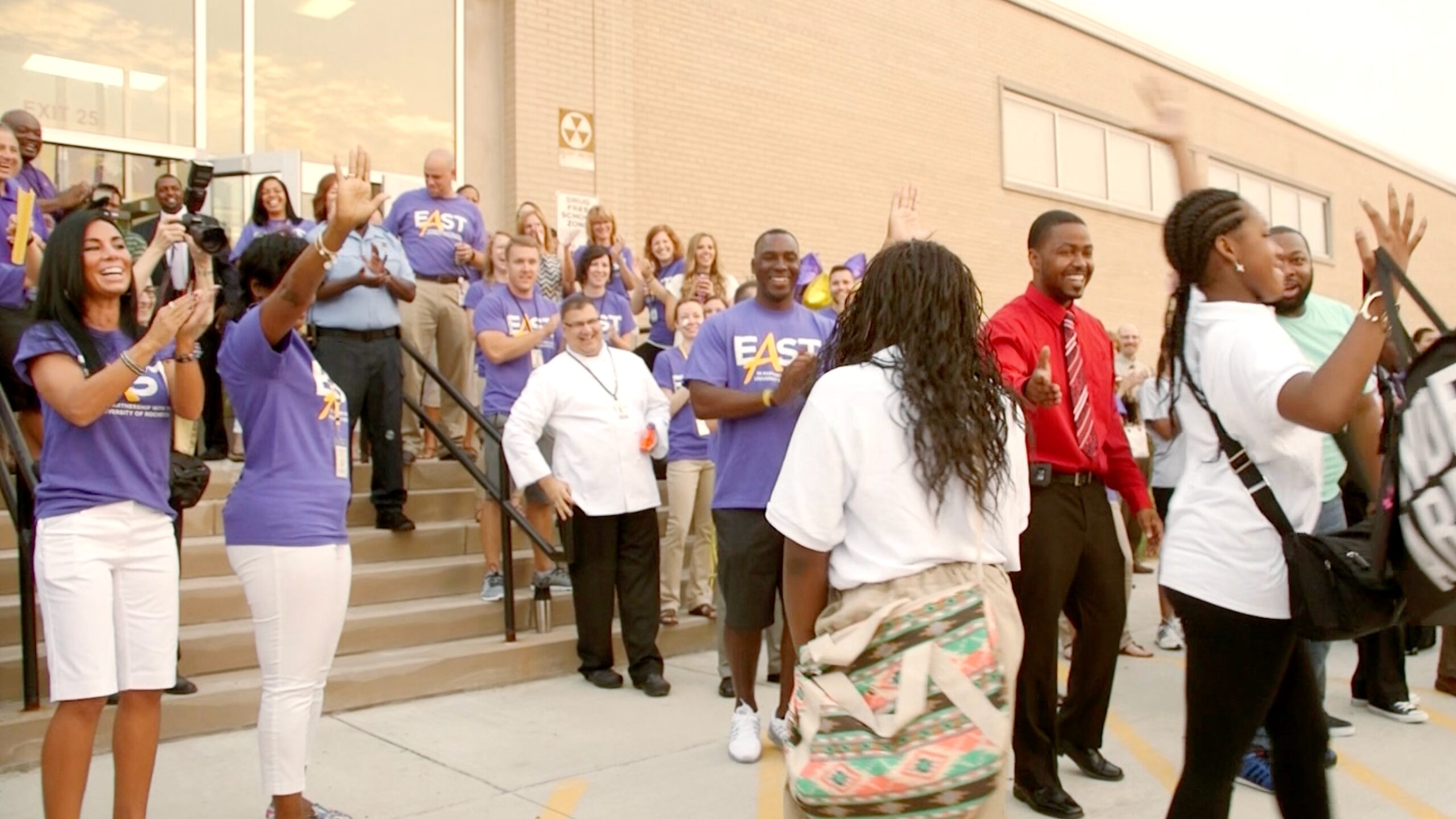 East students and teachers are celebrating outside the school's building.