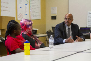 The Dean of the Warner school speaking with a table of young students