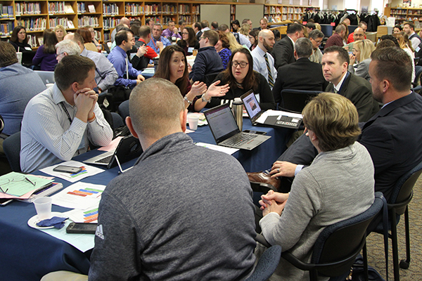 education professionals gathered around a table at a conference