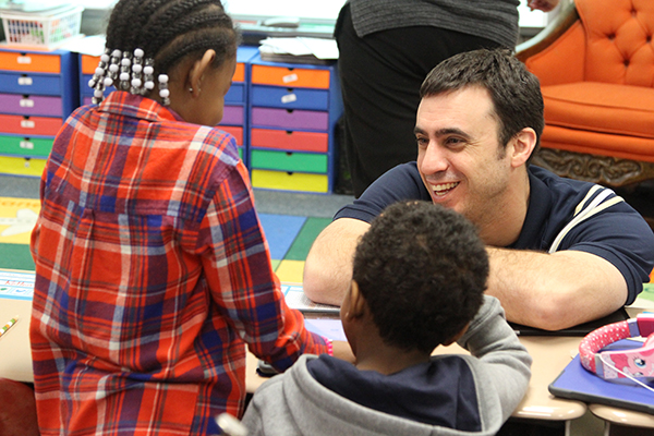IMG_2628 teacher smiling as he interacts with two students