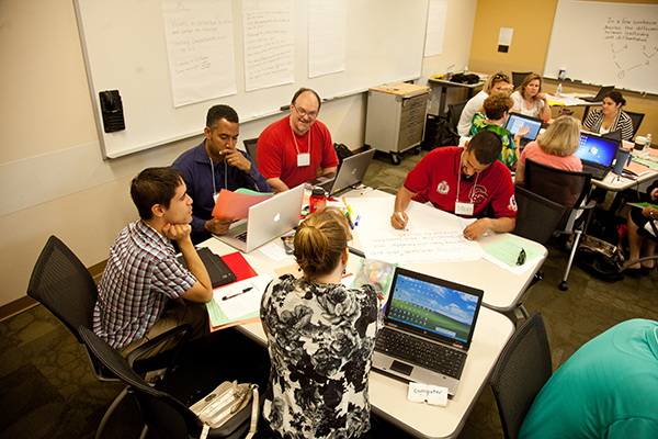 Warner Center CELLS workshop 2013 educators engaged in conversation around a table with laptops