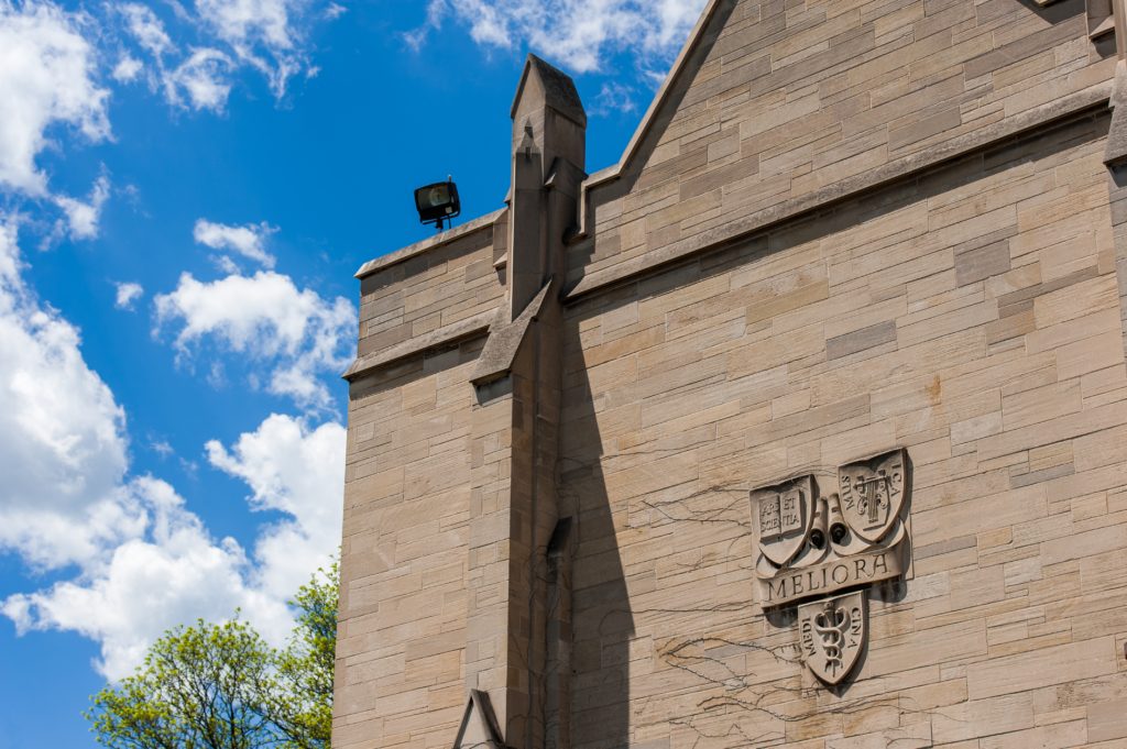 Meliora crest on the side of Cutler Union at the University of Rochester's Memorial Art Gallery